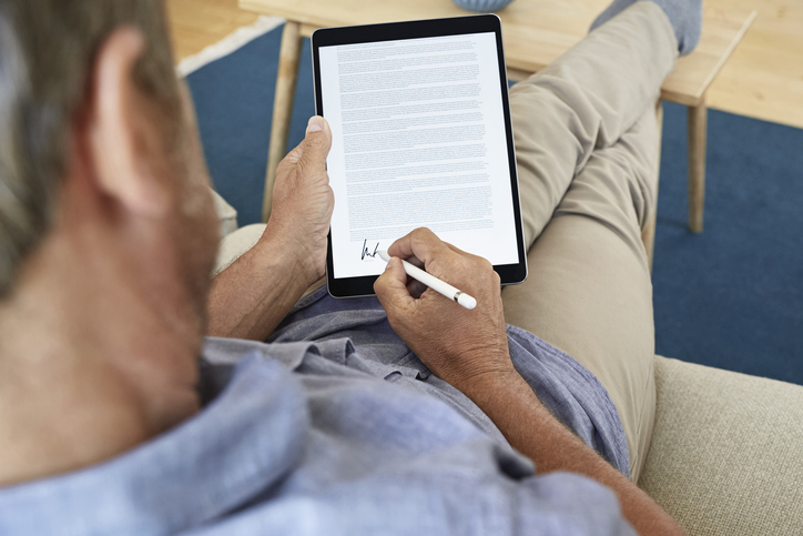 Mann unterschreibt Vertrag auf Tablet Mann unterschreibt Vertrag auf Tablet
